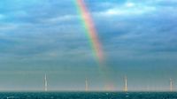 Regenbogen über Windrädern in der Nordsee am Morgen des 08.02.2022