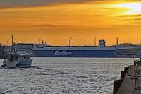 FINNWAVE (IMO 9468932, Finnlines) am 08.01.2022 bei Sonnenuntergang in Lübeck-Travemünde. Links im Bild: das Seebestattungs-Schiff TARMO II