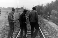 Streckenläufer der Reichsbahn und zwei DDR-Grenzsoldaten direkt an der Grenze bei der Bahnlinie Lübeck-Herrnburg