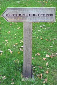 Hinweisschild LÜBECKER IMPFUNGLÜCK 1930 bei der Gedenkstätte Opfer von Krieg und Gewaltherrschaft - Vorwerker Friedhof in Lübeck, 12.09.2021