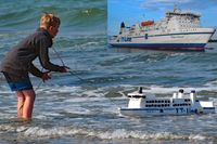 Junge mit Schiffsmodell der ROBIN HOOD an der Ostseeküste bei Travemünde